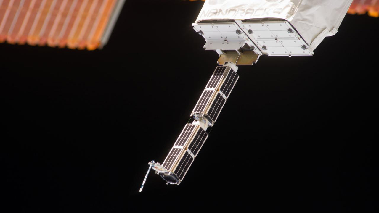The Small Satellite Orbital Deployer (SSOD), in the grasp of the Kibo laboratory robotic arm, is photographed by an Expedition 38 crew member on the International Space Station as it deploys a set of NanoRacks CubeSats. The CubeSats program contains a variety of experiments such as Earth observations and advanced electronics testing.