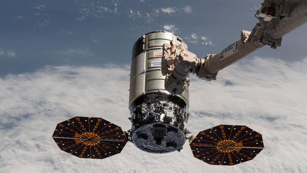 Northrop Grummans Cygnus space freighter approaches the International Space Station where the Canadarm2 robotic arm is poised to capture it for docking.