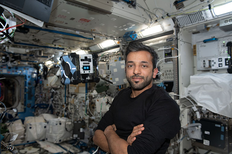 UAE astronaut Sultan Alneyadi poses with one of the Astrobees on the ISS.