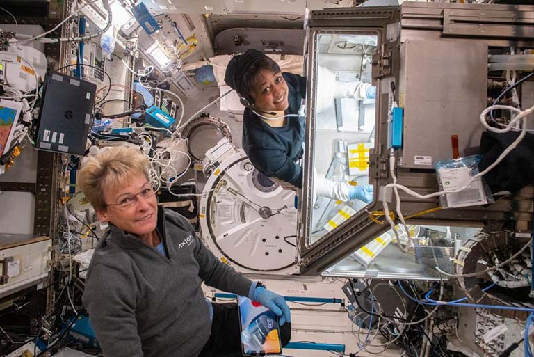 Axiom astronauts Peggy Whitson and Rayyanah Barnawi work on stem cell investigations on the ISS