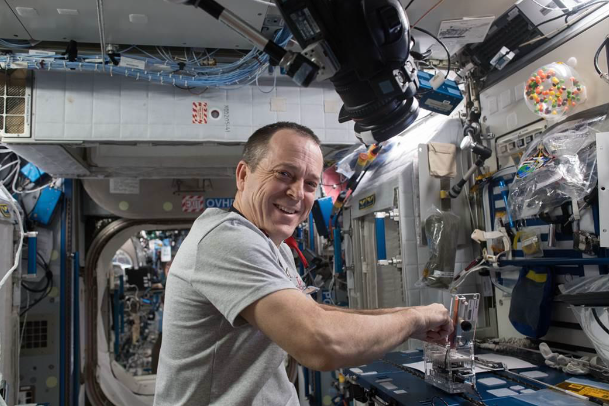 NASA Astronaut and Flight Engineer Ricky Arnold works with a student designed Genes in Space 5 experiment.