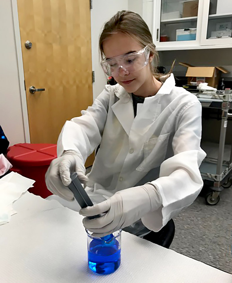 Kaitlyn Twesme prepares an inorganic chemical solution in the lab.