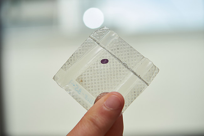 LambdaVisions tiny protein based retinal implant. The implant is the small purple dot, which is about the size of a paper hole punch.
