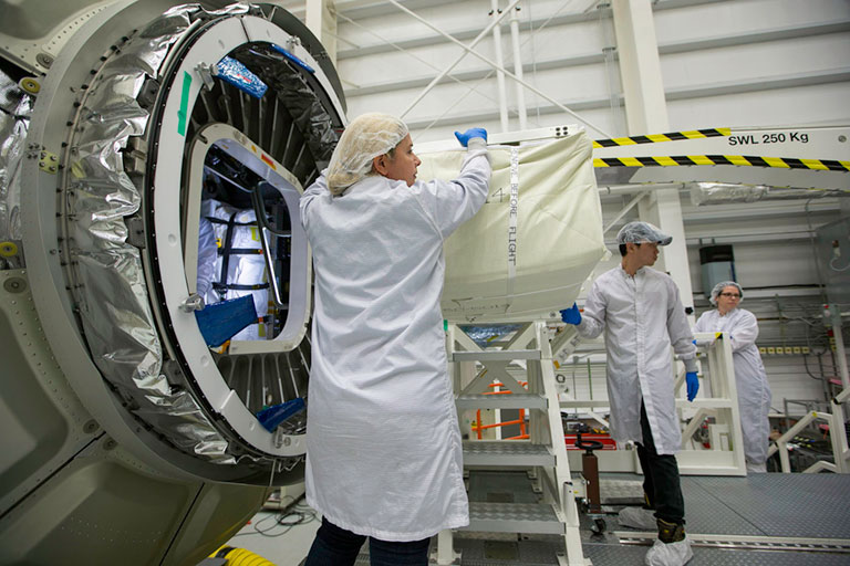 Engineers load the last of the cargo into the Cygnus capsule.