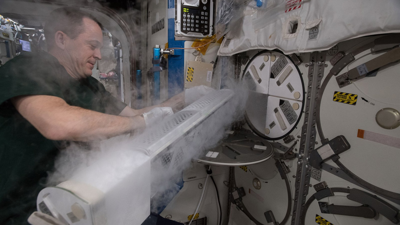 Astronaut Ricky Arnold removes PCG 9 sample bags containing Copper Sulfate from a Minus Eighty Degree Celsius Laboratory Freezer for ISS (MELFI) and checks them for crystal growth.