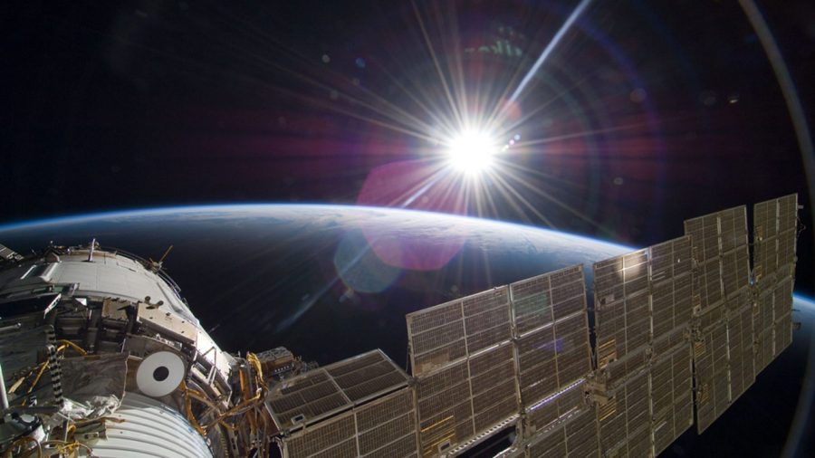 The bright sun greets the International Space Station and the Earth below.