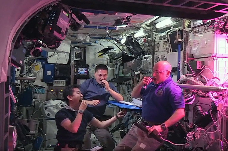 Astronauts Scott Kelly, Kjell Lindgren, and Kimiya Yui enjoy their first taste of lettuce they grew on the Space Station.