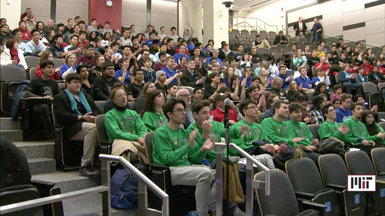 High schoolers watch the live ISS broadcast of the Zero Robotics Finals from an auditorium at MIT.
