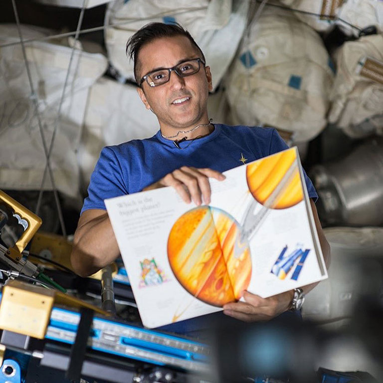 Flight Engineer Joe Acaba holds a childrens book that he is reading from as part of the Story Time From Space program. Astronauts read aloud from a STEM related childrens book while being videotaped and demonstrate simple science concepts and experiments onboard the ISS.