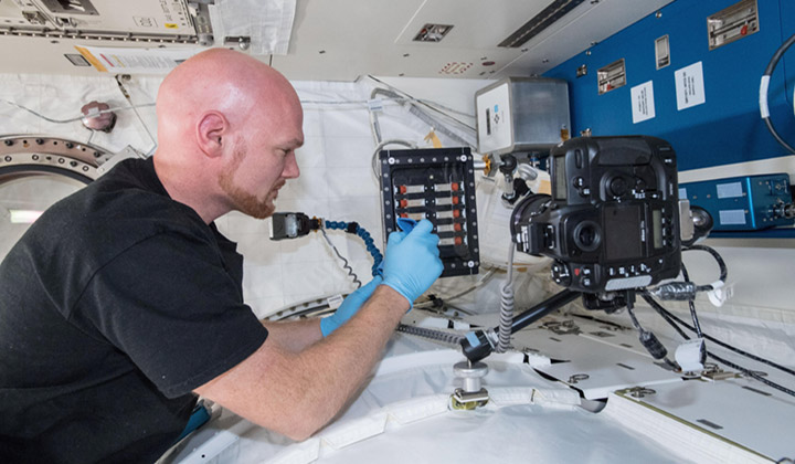 ESA astronaut Alexander Gerst onboard the ISS sets up the University of California, Santa Barbara experiment to examine the cohesive forces between sediment particles in microgravity.