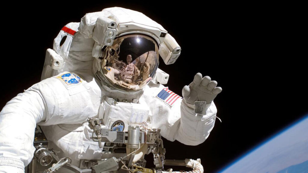 astronaut-spacewalk-earth-wave Astronaut Joseph R. Tanner, STS-115 mission specialist, waves during a spacewalk