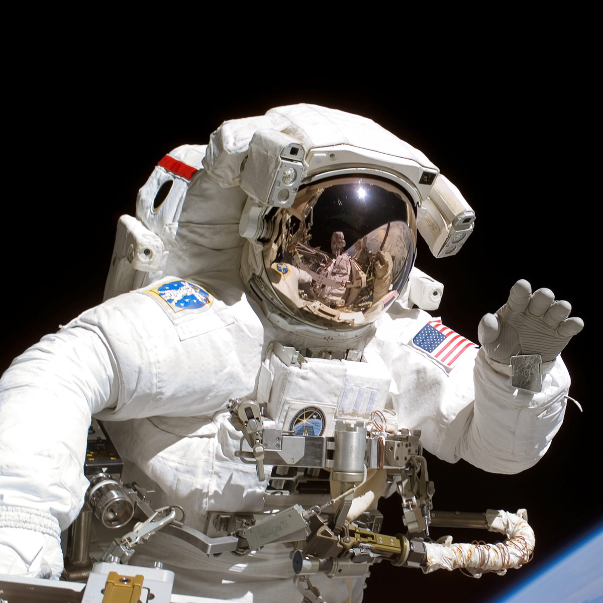 S115 E 05753 (12 Sept. 2006) Astronaut Joseph R. Tanner, STS 115 mission specialist, waves toward the digital still camera of his space walk colleague, astronaut Heidemarie M. Stefanyshyn Piper as the two share extravehicular activity (EVA) duties during the first of three scheduled spacewalks. The STS 115 astronauts and the Expedition 13 crew members are joining efforts this week to resume construction of the International Space Station.