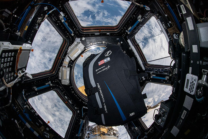 A prototype of a radiation shielding vest floats in the Cupola on the ISS.