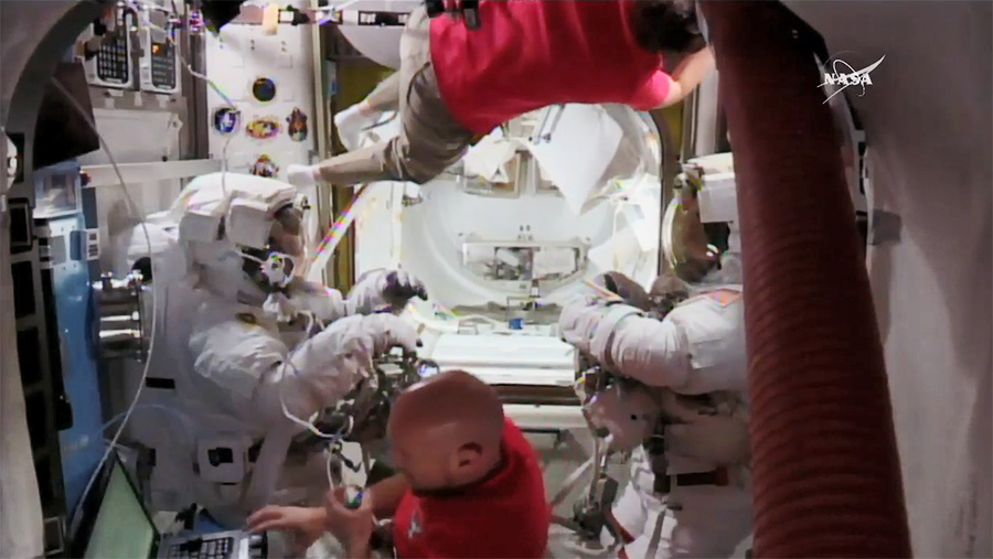 Spacewalkers Ricky Arnold (left) and Drew Feustel (right) are suited up inside the Quest airlock prior to beginning todays spacewalk. Astronauts Serena Aun Chancellor (top) and Alexander Gerst (bottom) assisted the duo.