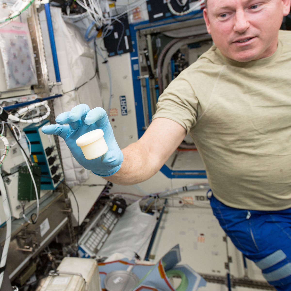 International Space Station astronaut Barry Butch Wilmore holds a science sample container that took two hours to make. The container was the first object to be printed with two parts: a lid and a container. NASA wants to make science equipment in space, rather than launching it.