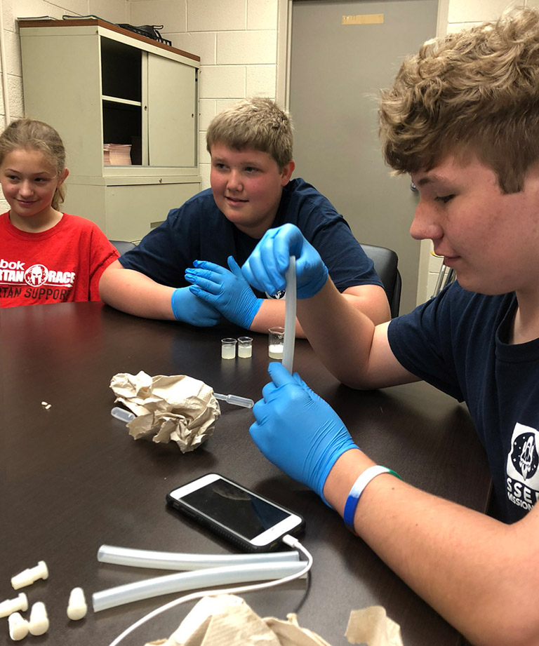 Nate loads one of the FME tubes with the saliva mixture. He said, It was kind of gross handling one of my best friends spit, but it was satisfying knowing that what I was doing was a product of the teams hard work and commitment.