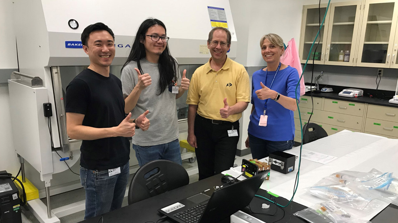 Jonathan Tsui and Ty Higashi of the University of Washington and Paul Koenig and Stefanie Countryman of BioServe Space Technologies with the Engineered Heart Tissue hardware in the Space Station Processing Facility before the launch of SpaceX CRS 20.