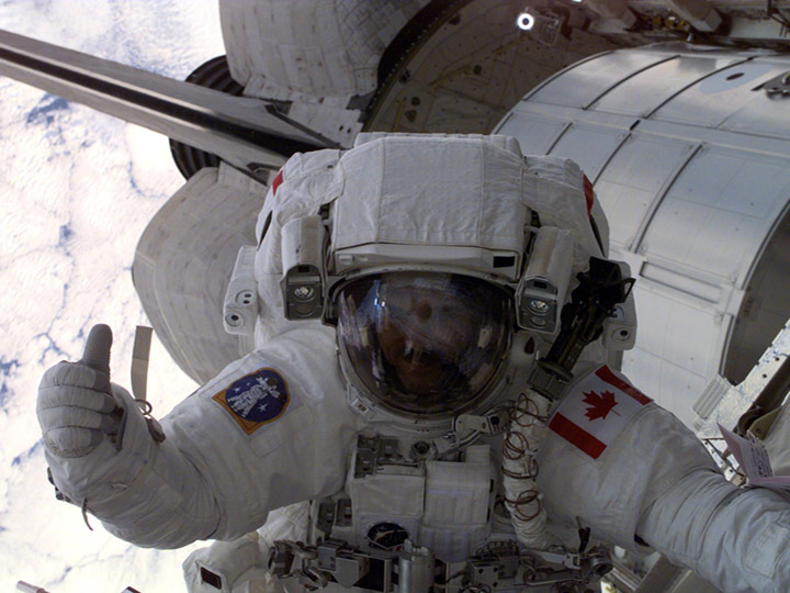 April 2001 Astronaut Chris A. Hadfield, mission specialist representing the Canadian Space Agency, gives fellow astronauts the thumbs up during the first spacewalk of the STS 100 shuttle mission during Expedition 2 on the station.