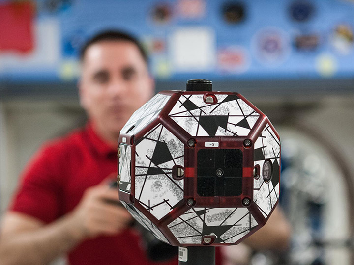 SS036 E 031693 (13 Aug. 2013) A close up view of a bowling ball sized free flying satellite known as Synchronized Position Hold, Engage, Reorient, Experimental Satellites, or SPHERES is pictured during a session in the International Space Stations Kibo laboratory. NASA astronaut Chris Cassidy, Expedition 36 flight engineer, is visible in the background.