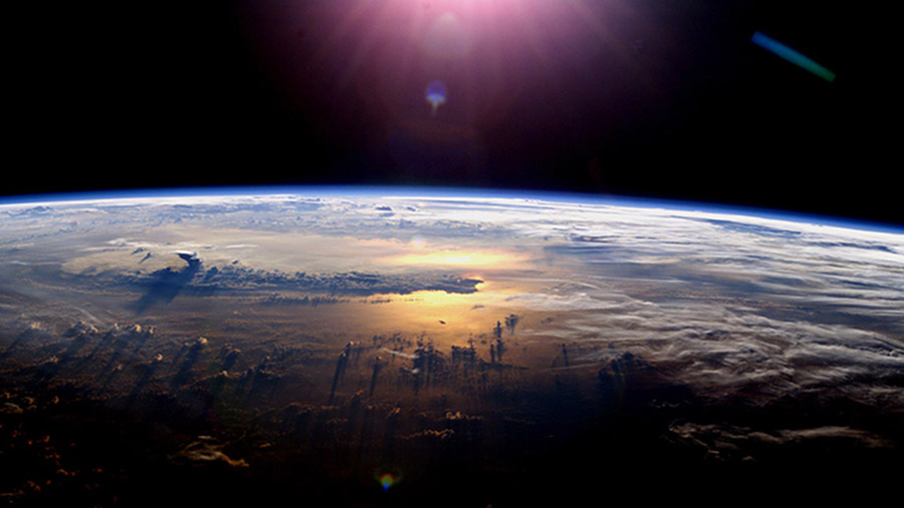 The setting of the sun over the Pacific Ocean and a towering thundercloud, July 21, 2003 as seen from the International Space Station