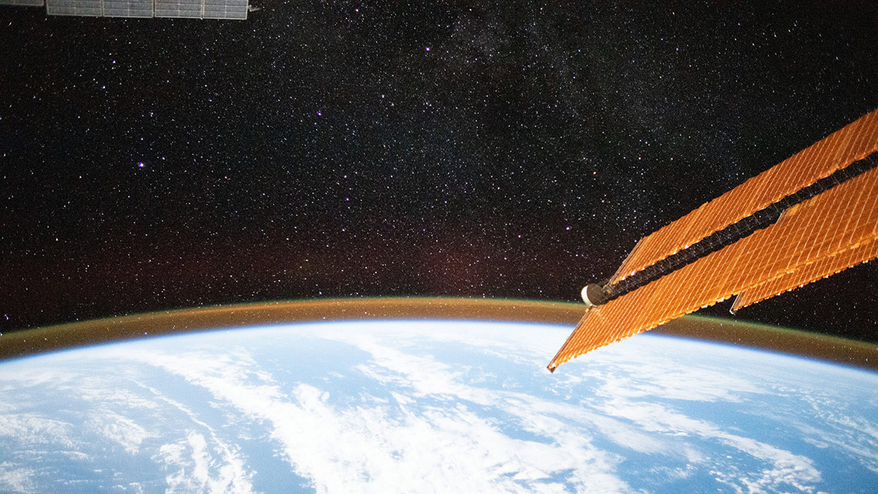 This long exposure photograph captures a starry sky above the Earths atmospheric glow as the International Space Station orbited above the Indian Ocean about halfway between South Africa and Australia.