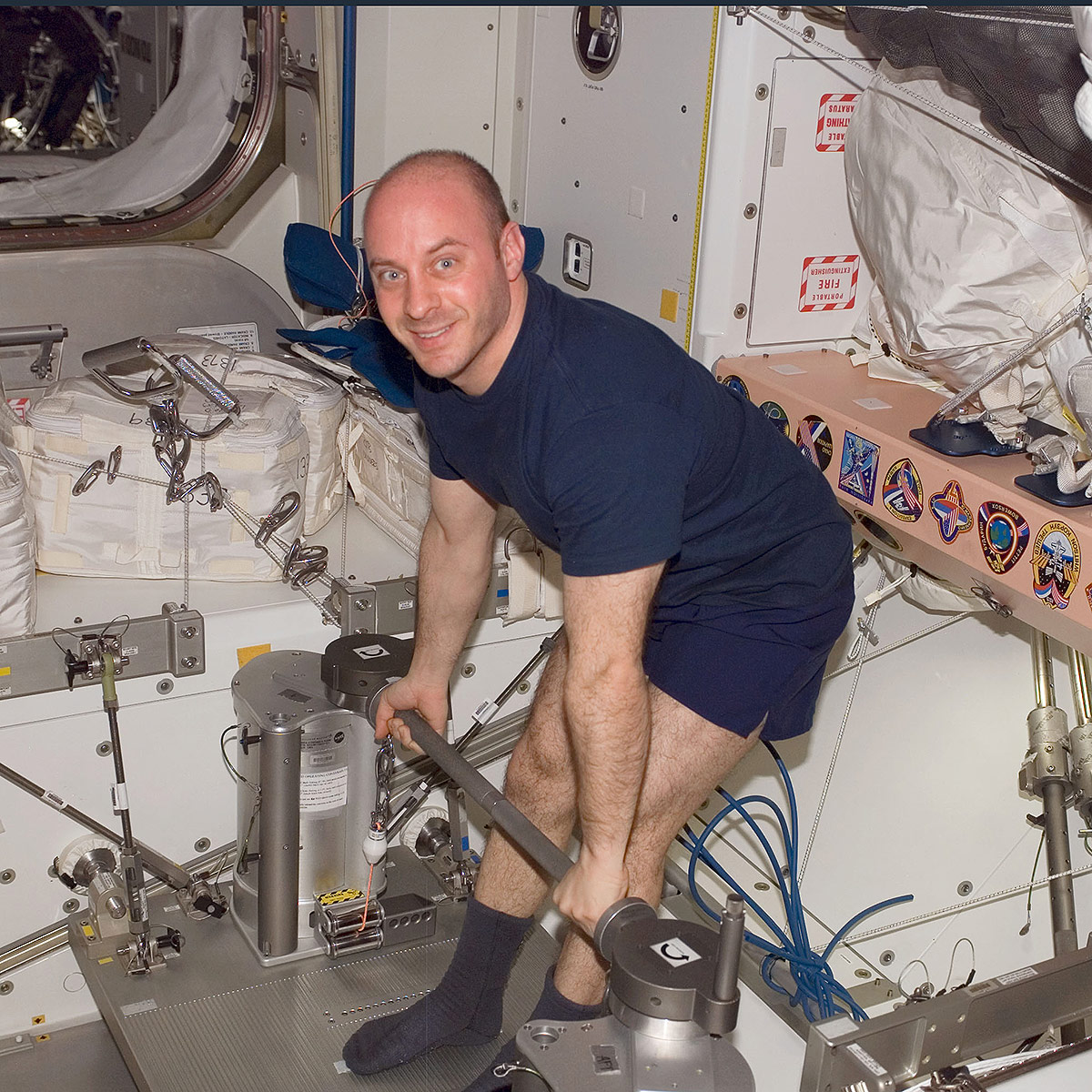 ISS017 E 006630 (11 May 2008) NASA astronaut Garrett Reisman, Expedition 17 flight engineer, uses the short bar for the Interim Resistive Exercise Device (IRED) equipment to perform upper body strengthening pull ups in the Unity node of the International Space Station.