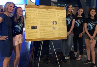 Higher Orbits founder and president Michelle Lucas (left) poses with three of the four Team NESS members at their poster shortly before the SpaceX CRS 15 launch.