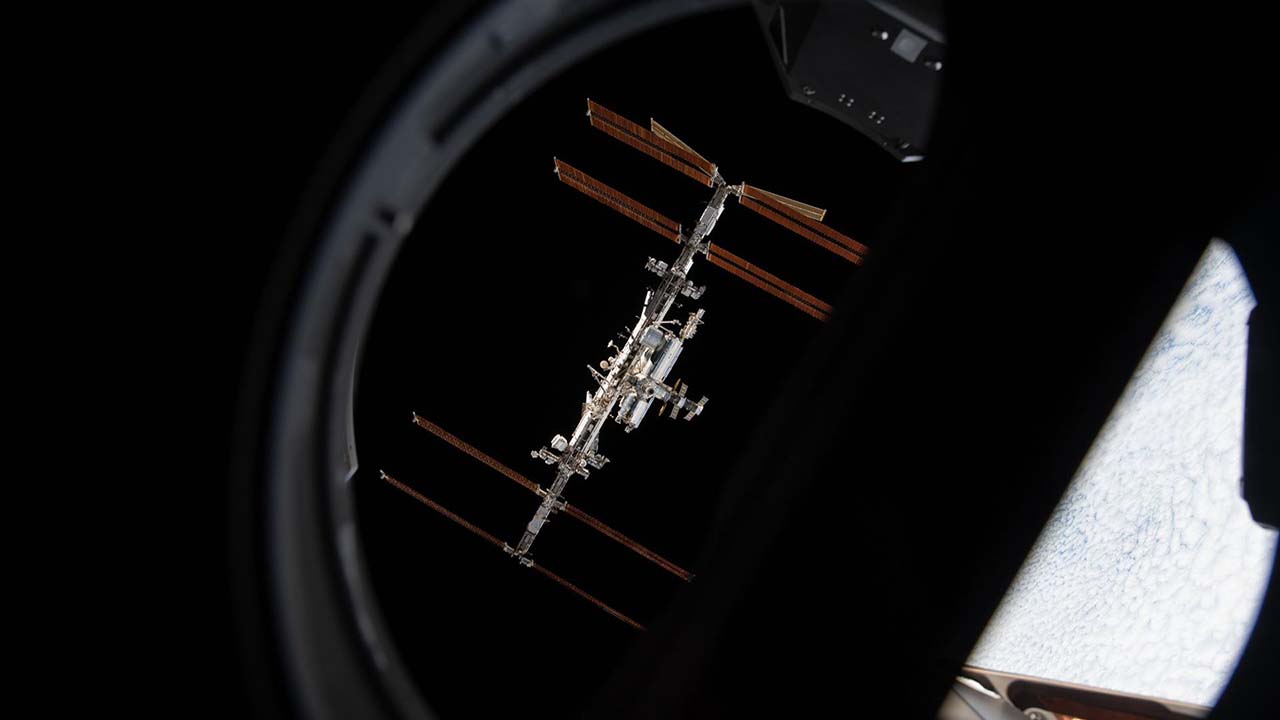 The International Space Station is pictured from inside a window aboard the SpaceX Crew Dragon Endeavour