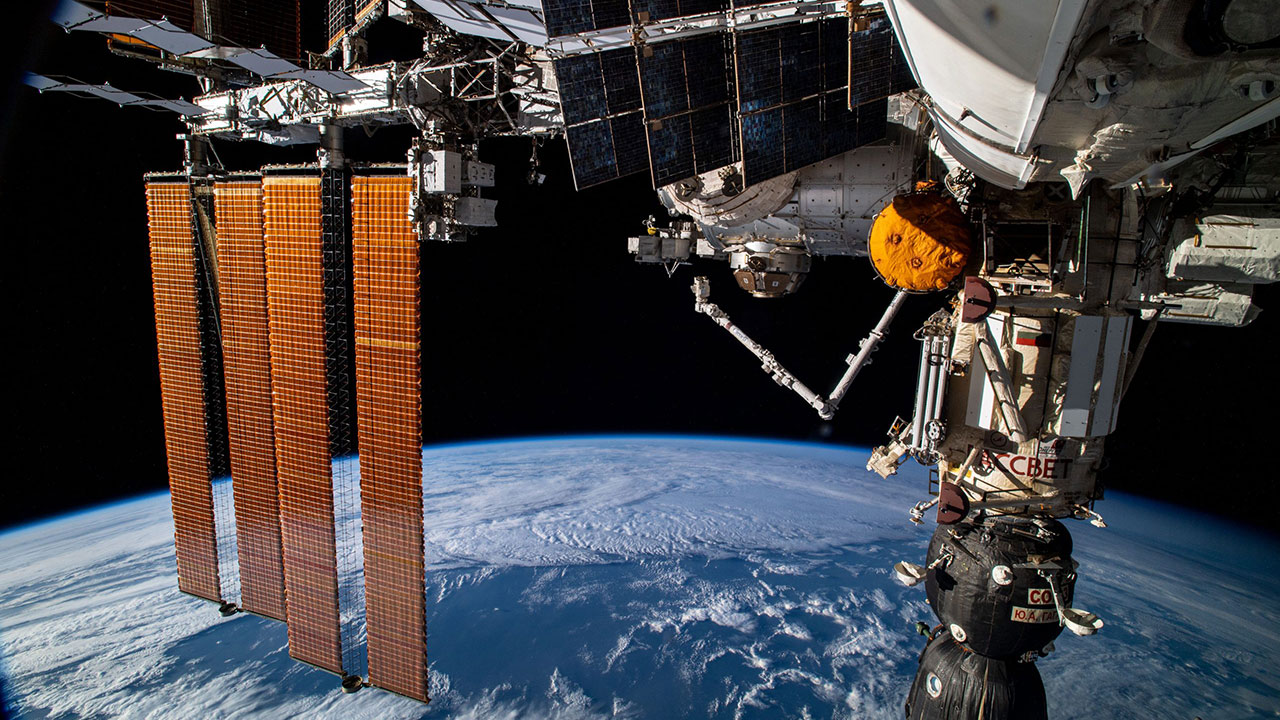 Looking from back to front, the International Space Stations Russian segment is pictured leading to the U.S. segment while orbiting 273 miles above the south Atlantic Ocean. At top right, is the Zarya module with the Rassvet module and the docked Soyuz MS 18 crew ship. The Canadarm2 robotic arm is seen next to the Tranquility module to which the cupola and BEAM, the Bigelow Expandable Activity Module, are attached. Two pairs of the stations main solar arrays are also seen descending from the orbiting labs port side truss structure.