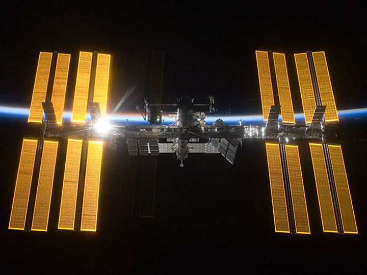 The International Space Station taken from Space Shuttle Discovery as the Sun rises from behind Earth. The STS 119 and Expedition 18 crew took this picture after leaving the Space Station in March 2009.