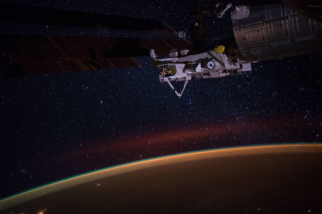Earths atmospheric glow, the stars of the Milky Way and an experiment facility at the tip of Japans Kibo lab module are seen in this night time photograph taken during Expedition 49.