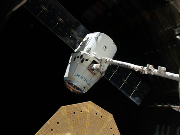 iss058e002666 (Jan. 13, 2019) The SpaceX Dragon cargo craft is pictured in the grips of the Canadarm2 robotic arm before its release and departure from the International Space Station. Featured prominently in the lower foreground is one of two cymbal shaped UltraFlex solar arrays attached to the Northrop Grumman Cygnus resupply ship. The orbital complex was orbiting 254 miles above East Asia at the time this photograph was taken.