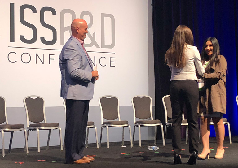 Ken Shields (left), CASIS Director of Operations and STEM Education, and Emily Calandrelli (center), producer and host of FOXs Xploration Outer Space, presented the award to Julissa Herrera (right).