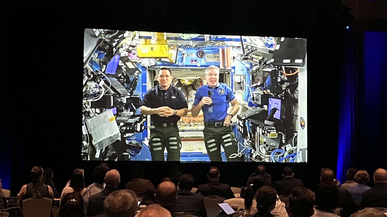 Attendees at ISSRDC 2023 listen to a welcome address from astronauts onboard the ISS.