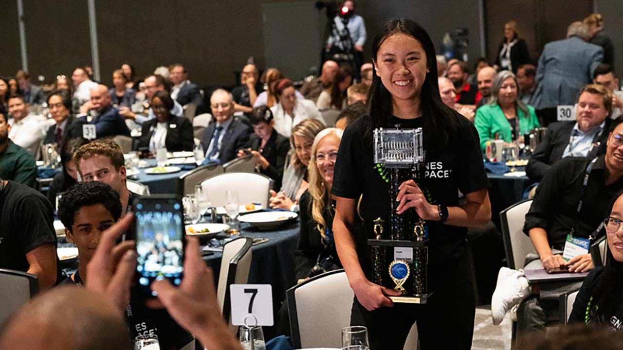 Isabel Jiang poses with her trophy after winnign the 2023 Genes in Space student research contest.