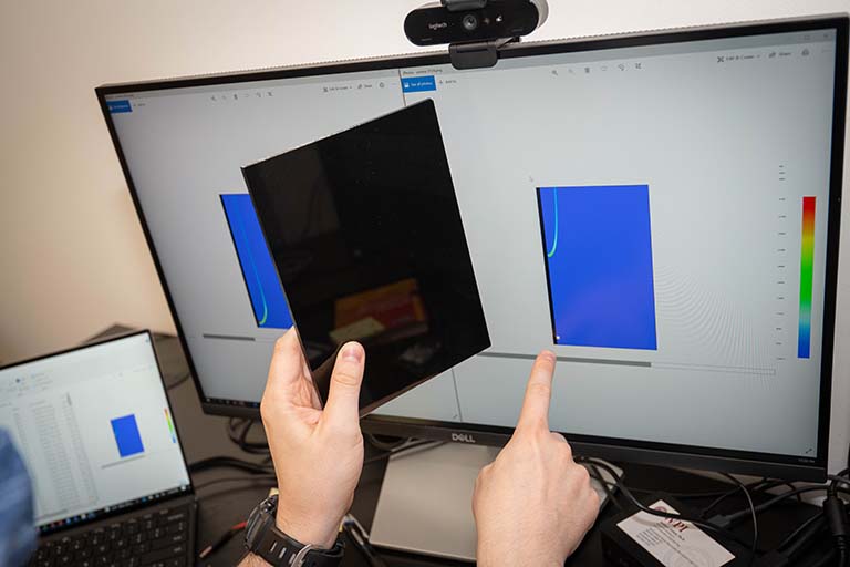 James Urban, assistant professor of fire protection engineering at Worcester Polytechnic Institute, shows off a strip of the plastic fuel medium he will use in his ISS experiment alongside a visualization of a simulated flame flow.