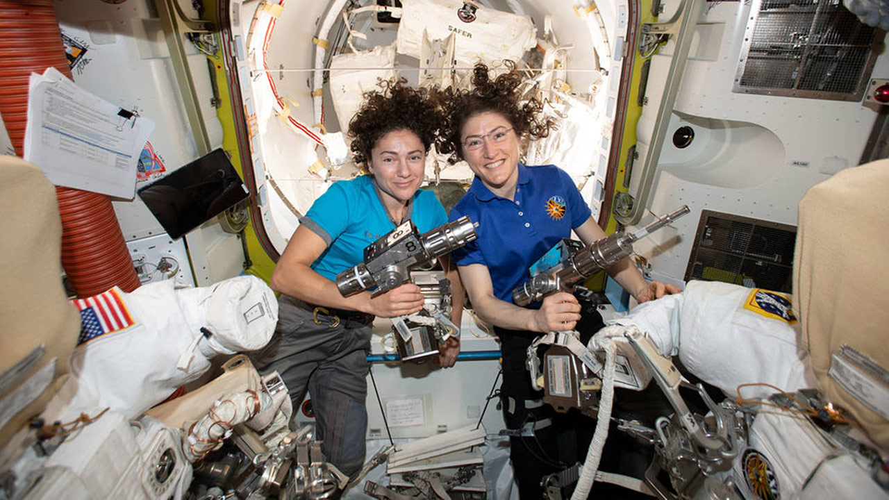 NASA astronauts Jessica Meir (left) and Christina Koch are inside the Quest airlock preparing the U.S. spacesuits and tools they will use on their first spacewalk together.