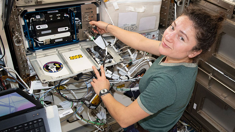 NASA astronaut Jessica Meir works with the Techshot Bone Densitometer to assess bone density of the animal subjects for the Mighty Mice investigation.