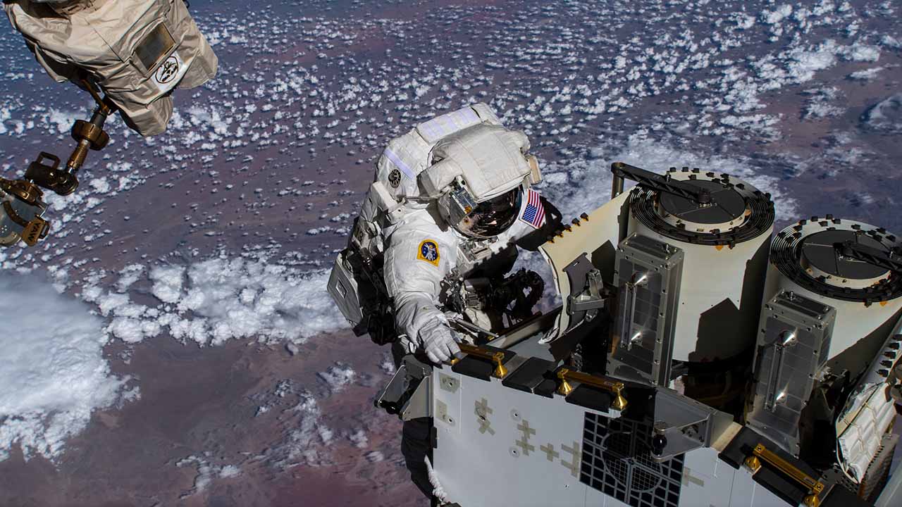 iss068e031766 (Dec. 22, 2022) Expedition 68 Flight Engineer and NASA spacewalker Josh Cassada prepares a roll out solar array for its deployment on the International Space Stations Port 4 truss segment as the orbiting lab flew 262 miles above the Atlantic Ocean off the coast of Namibia.