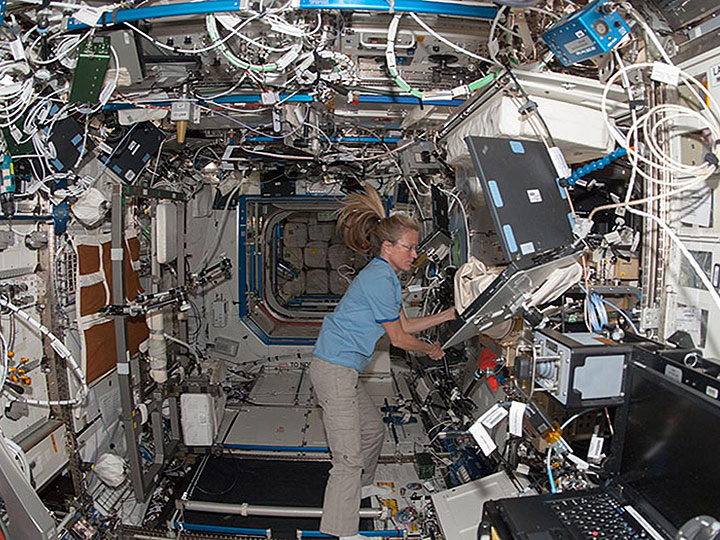 iss036e019758 In the International Space Stations Destiny laboratory,NASA astronaut Karen Nyberg,Expedition 36 flight engineer,speaks into a microphone while conducting a session with the Advanced Colloids Experiment (ACE) 1 sample preparation at the Light Microscopy Module (LMM) in the Fluids Integrated Rack   Fluids Combustion Facility (FIR FCF). ACE 1 is a series of microscopic imaging investigations that uses the microgravity environment to examine flow characteristics and the evolution and ordering effects within a group of colloidal materials.