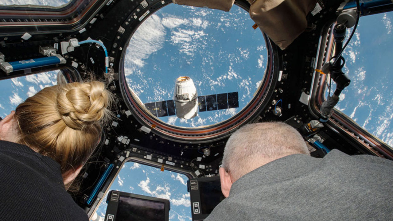 NASA astronauts Kate Rubins (left) and Jeff Williams (right) prepare to grapple the SpaceX Dragon supply spacecraft from aboard the International Space Station.