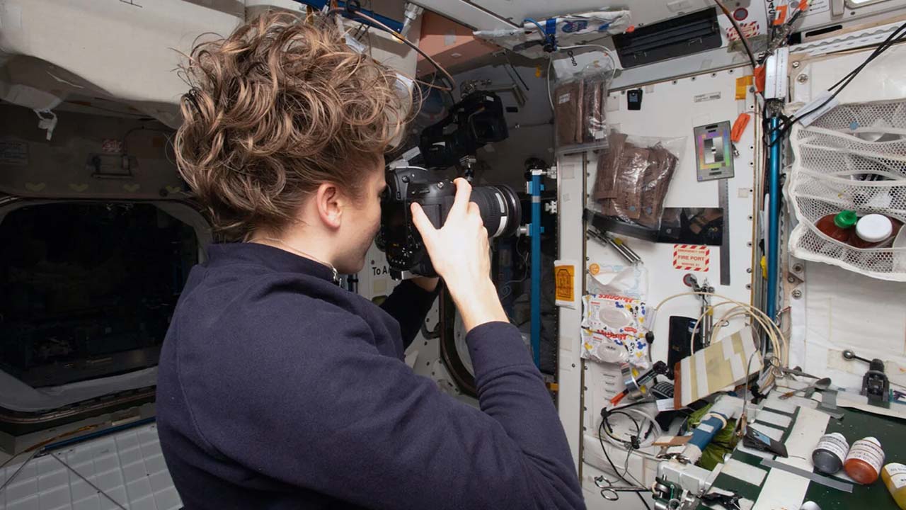 NASA astronaut Kayal Barron photographs a sample location in the galley area of Node 1 as part of the SQuARE experiment, which used archaeological techniques to analyze various locations around the ISS and understand how people adapt to life in space.