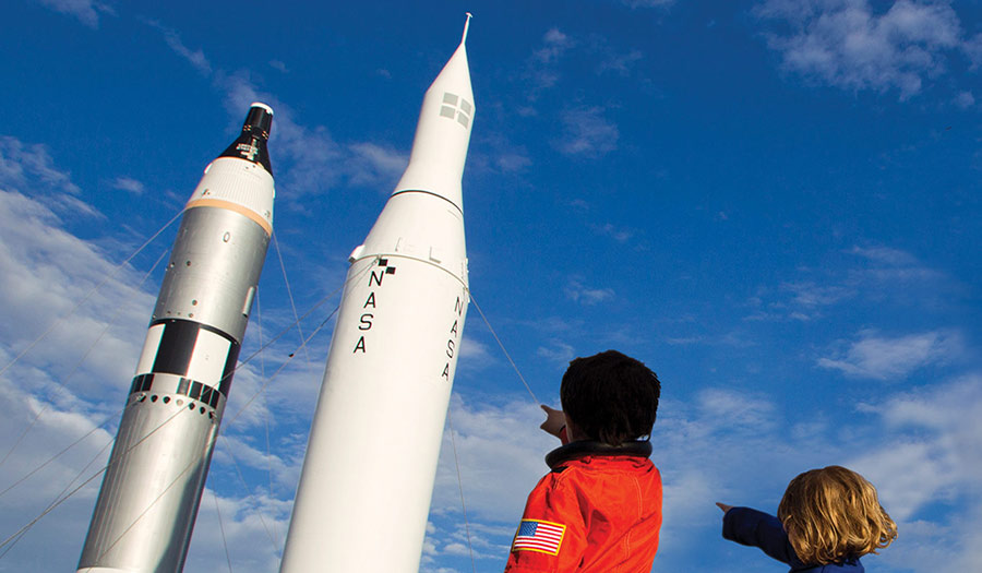 Inspired youth stand in Kennedy Space Centers rocket garden on SpaceX CRS 11 launch day.
