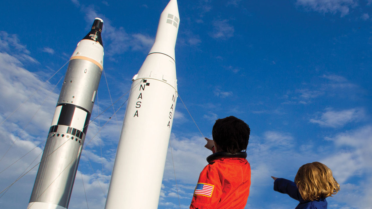 kids pointing rockets sky