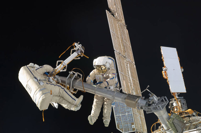 This image of Russian cosmonauts Oleg Kononenko and Anton Shkaplerov, both Expedition 30 flight engineers, was taken during a spacewalk on Thursday, Feb. 16, 2012. During the six hour, 15 minute spacewalk, Kononenko and Shkaplerov moved the Strela 1 crane from the Pirs Docking Compartment in preparation for replacing it in 2012 with a new laboratory and docking module. The duo used another boom, the Strela 2, to move the hand operated crane to the Poisk module for future assembly and maintenance work. Both telescoping booms extend like fishing rods and are used to move massive components outside the station. On the exterior of the Poisk Mini Research Module 2, they also installed the Vinoslivost Materials Sample Experiment, which will investigate the influence of space on the mechanical properties of the materials. The spacewalkers also collected a test sample from underneath the insulation on the Zvezda Service Module to search for any signs of living organisms. Both spacewalkers wore Russian Orlan spacesuits bearing blue stripes and equipped with NASA helmet cameras.