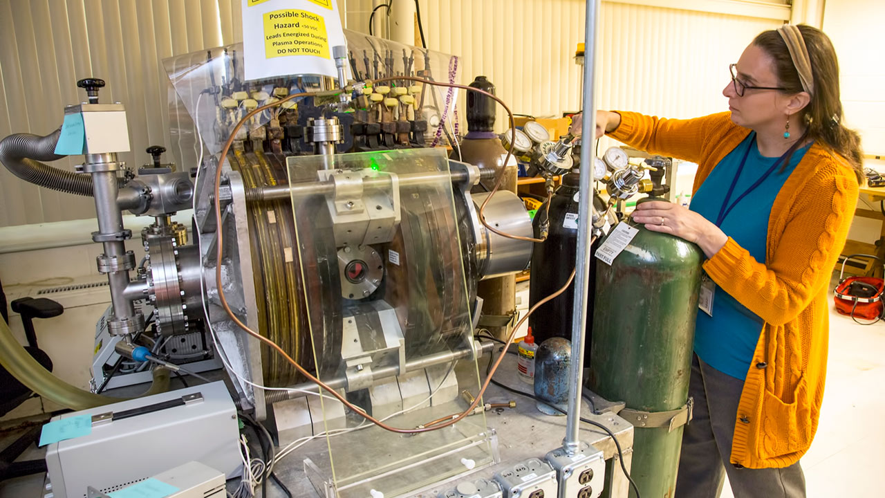 Lenore Rasmussen, Ph.D., principal investigator of the Synthetic Muscle investigation, checks the pressure during the oxygen plasma treatment of titanium metal support mounts at the U.S. Department of Energys Princeton Plasma Physics Laboratory. The mounts are supporting the samples during flight on the International Space Station