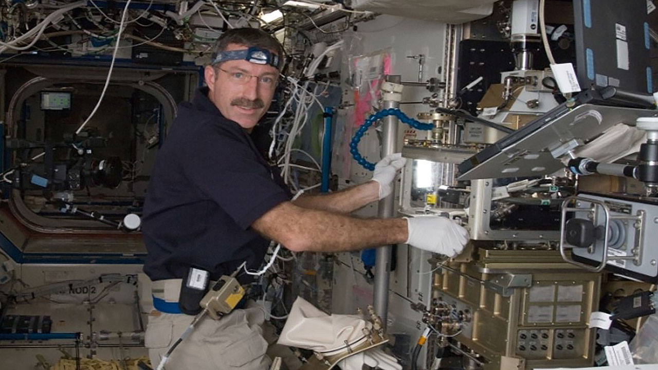 In the International Space Stations Destiny laboratory, NASA astronaut Dan Burbank, Expedition 30 commander, conducts research at the Light Microscopy Module (LMM).