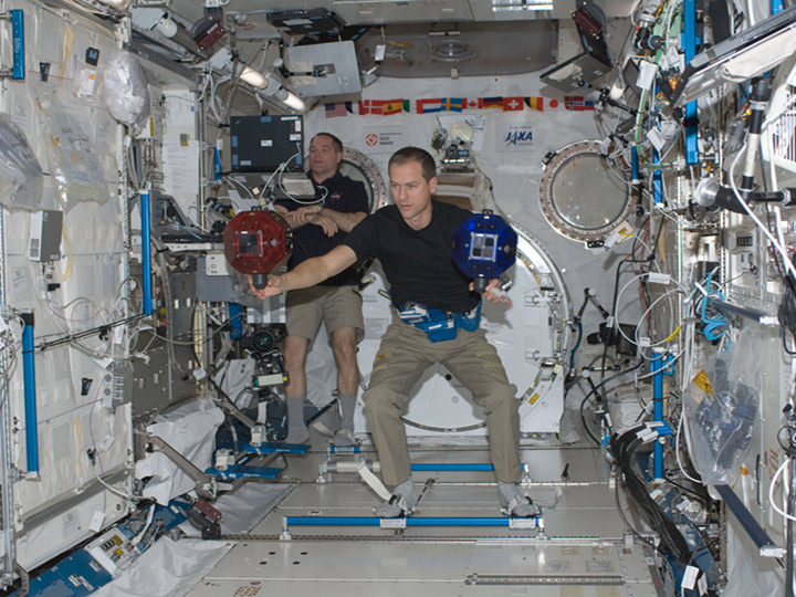 NASA astronauts Kevin Ford (background) and Tom Marshburn, setting up two Spheres robots in the Kibo laboratory on the International Space Station. The volleyball sized satellites have their own power, propulsion and navigation systems and are used in an international competition for high school students.