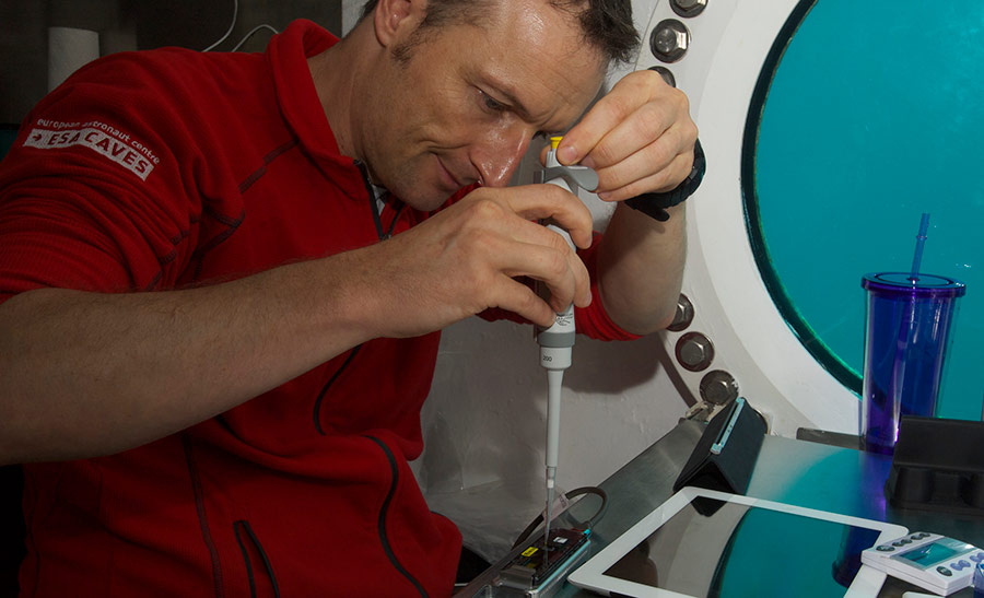 NASA Extreme Environment Mission Operations (NEEMO) crew member, Matthias Maurer of ESA, works on inserting samples into the MinION DNA sequencer as part of the Biomolecule Sequencer experiment. Researchers tested the device aboard the analog to minimize unknowns and see how the device worked in various extreme environments.