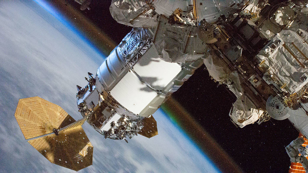 iss064e047042 (March 28, 2021) The Cygnus resupply ship, with its prominent cymbal shaped UltraFlex solar arrays, from Northrop Grumman is pictured attached to the International Space Stations Unity module. Earths atmospheric glow is seen blanketing the horizon as the orbital complex flew 262 miles above Ethiopia on the African continent.